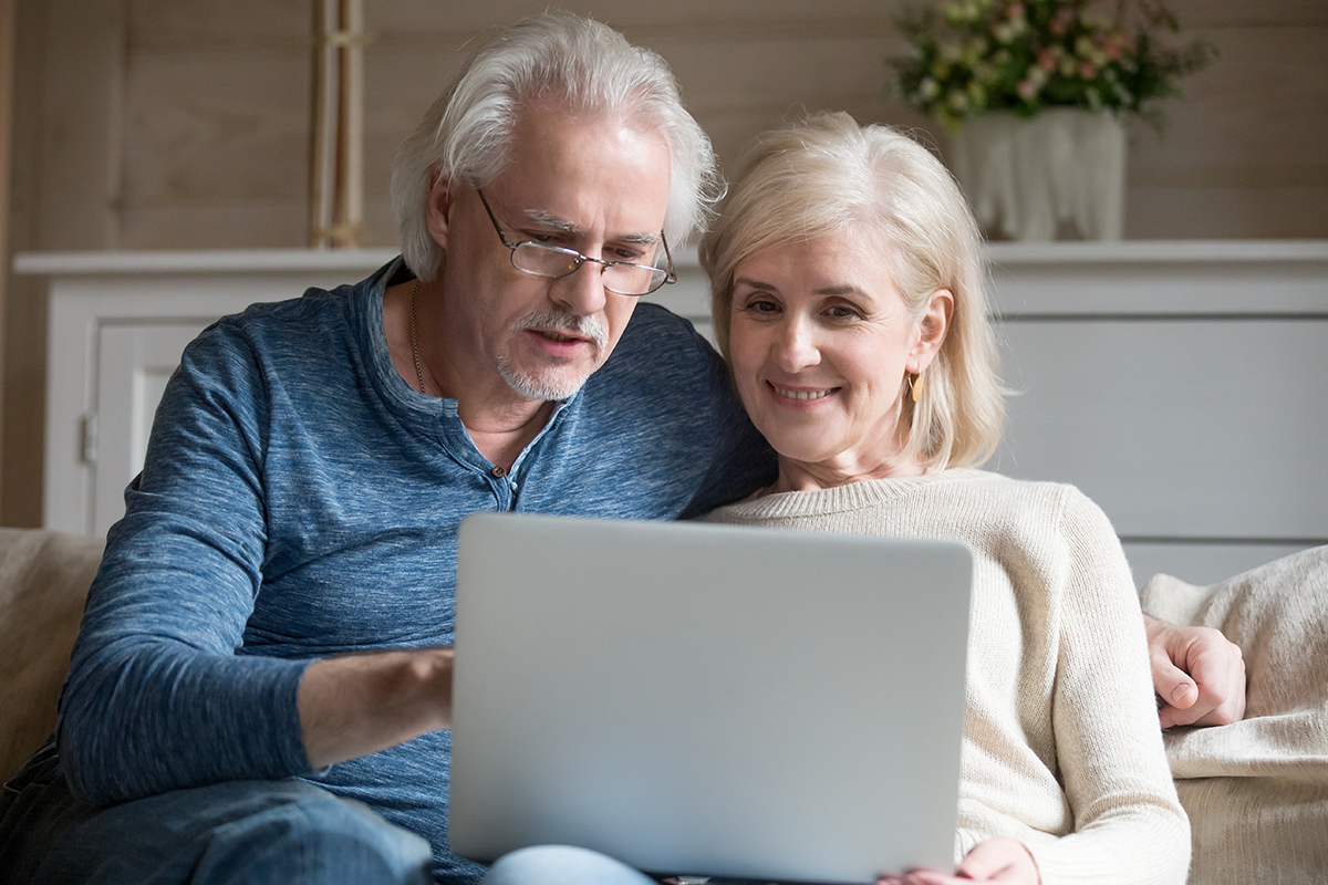 Man en vrouw kijken naar laptop op bank