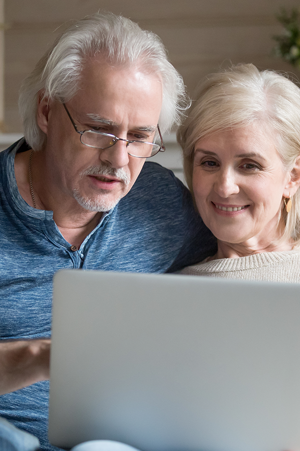Man en vrouw kijken naar laptop op bank
